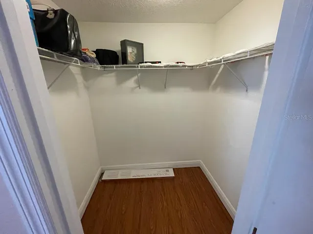 a view of walk in closet with wooden floor