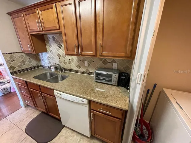 a kitchen with stainless steel appliances granite countertop a sink stove and a refrigerator