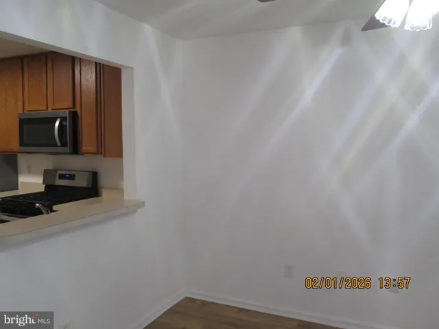a view of kitchen with wooden floor and cabinets