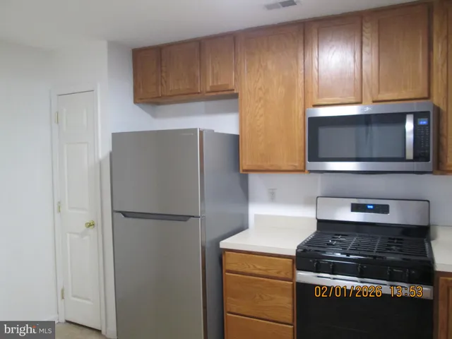 a kitchen with stainless steel appliances granite countertop a stove a refrigerator and a cabinets with wooden floor