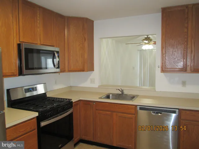 a kitchen with granite countertop stainless steel appliances a stove microwave and sink
