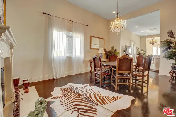 a living room with furniture a chandelier and a dining table