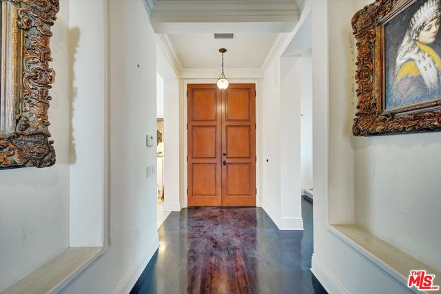 a view of a hallway with wooden floor and cabinet