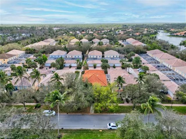 an aerial view of residential houses with outdoor space and trees
