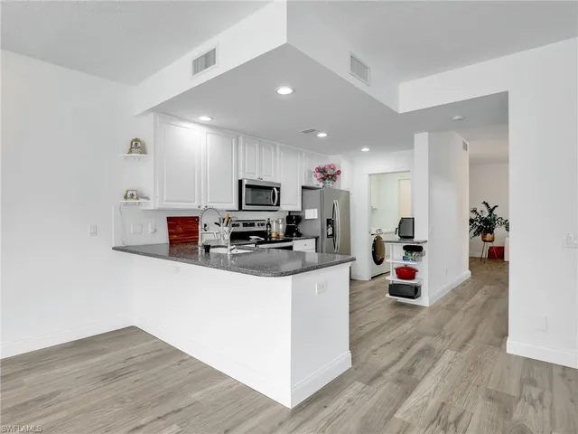 a kitchen with stainless steel appliances a refrigerator sink and microwave