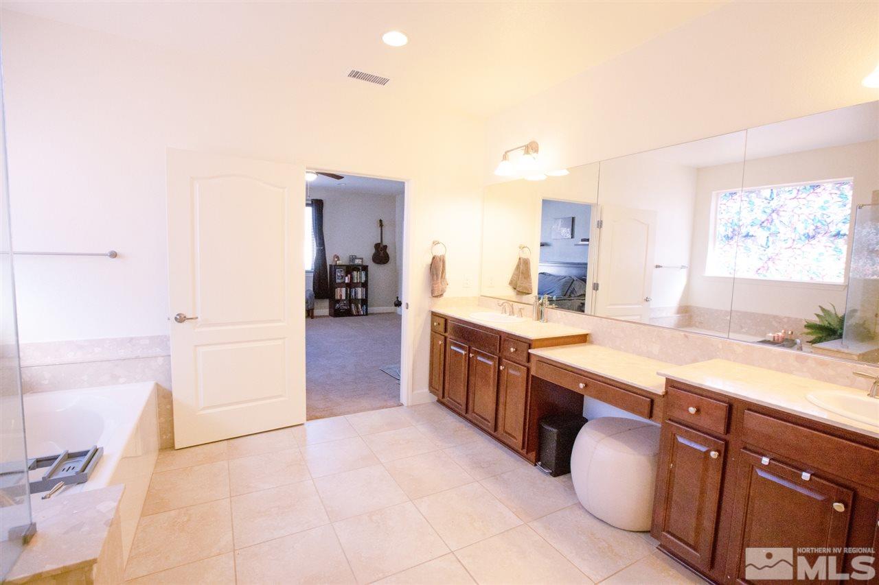 1885 Fledge Creek Drive Reno, NV 89521 - Photo 16 of 30 a large bathroom with a granite countertop double vanity sink a mirror and a bathtub