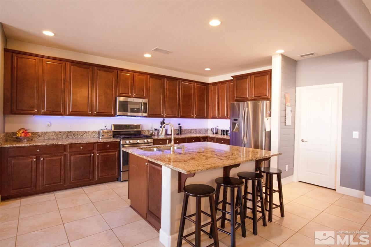 1885 Fledge Creek Drive Reno, NV 89521 - Photo 6 of 30 a kitchen with stainless steel appliances granite countertop wooden cabinets a stove top oven a sink and dishwasher