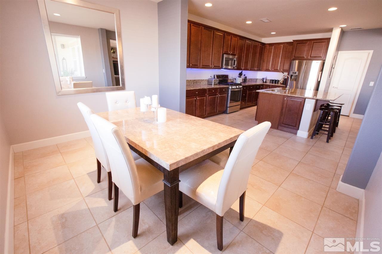 1885 Fledge Creek Drive Reno, NV 89521 - Photo 8 of 30 a kitchen with a dining table chairs and refrigerator