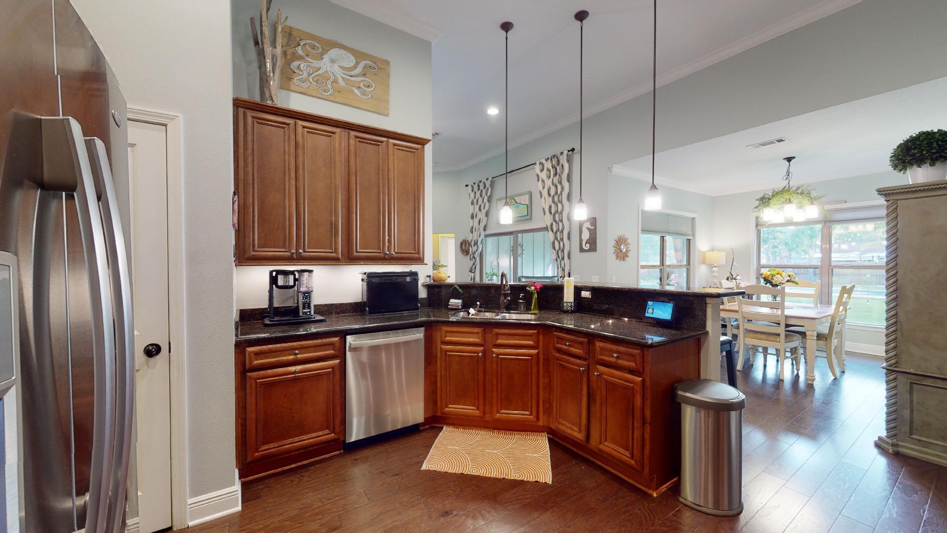 1959 Commodore Drive Navarre, FL 32566 - Photo 19 of 56 a kitchen with stainless steel appliances granite countertop a refrigerator a sink dishwasher a stove and white countertops with wooden floor