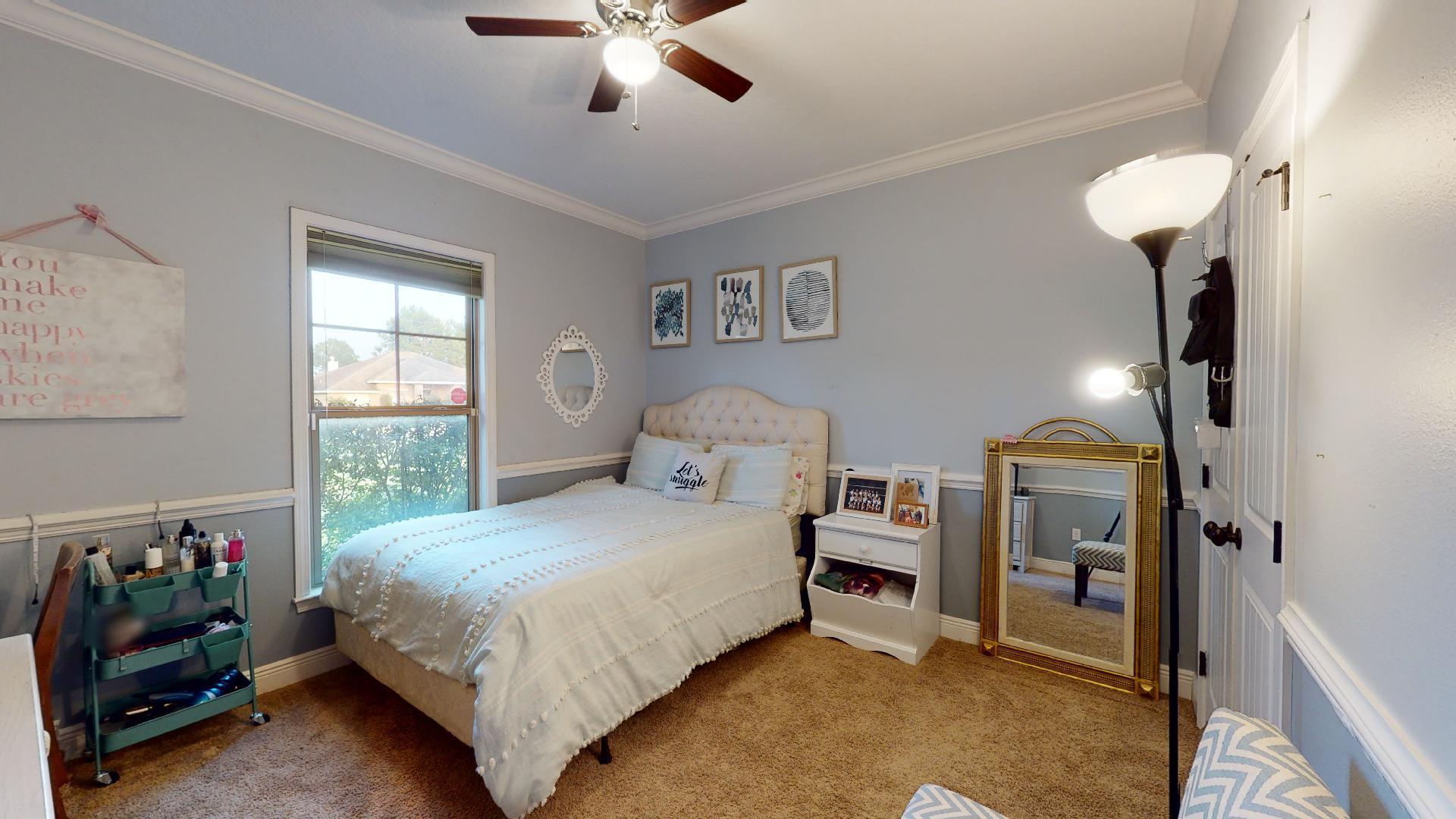 1959 Commodore Drive Navarre, FL 32566 - Photo 32 of 56 a bedroom with a bed and a chandelier