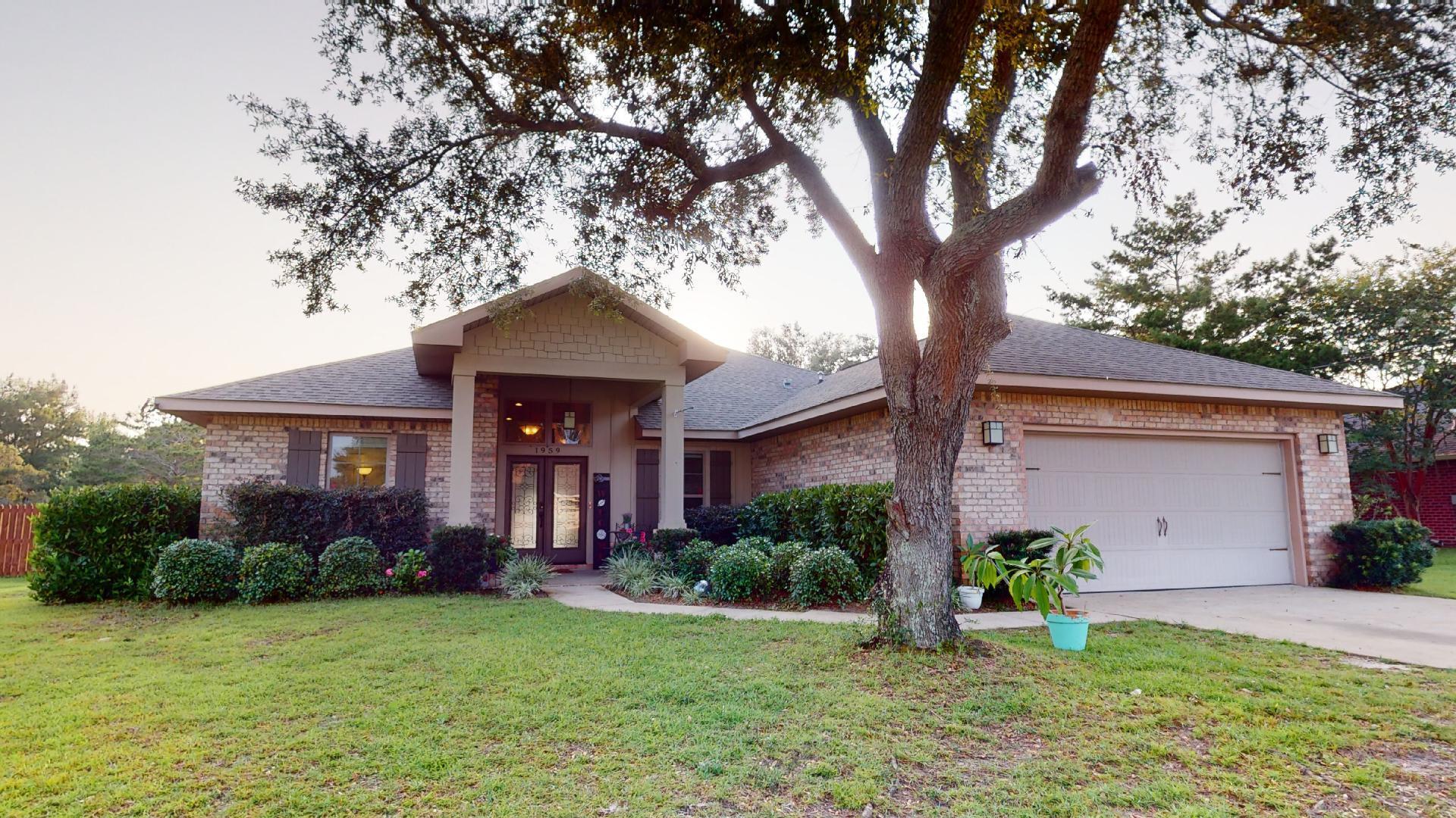 1959 Commodore Drive Navarre, FL 32566 - Photo 4 of 56 a front view of a house with garden