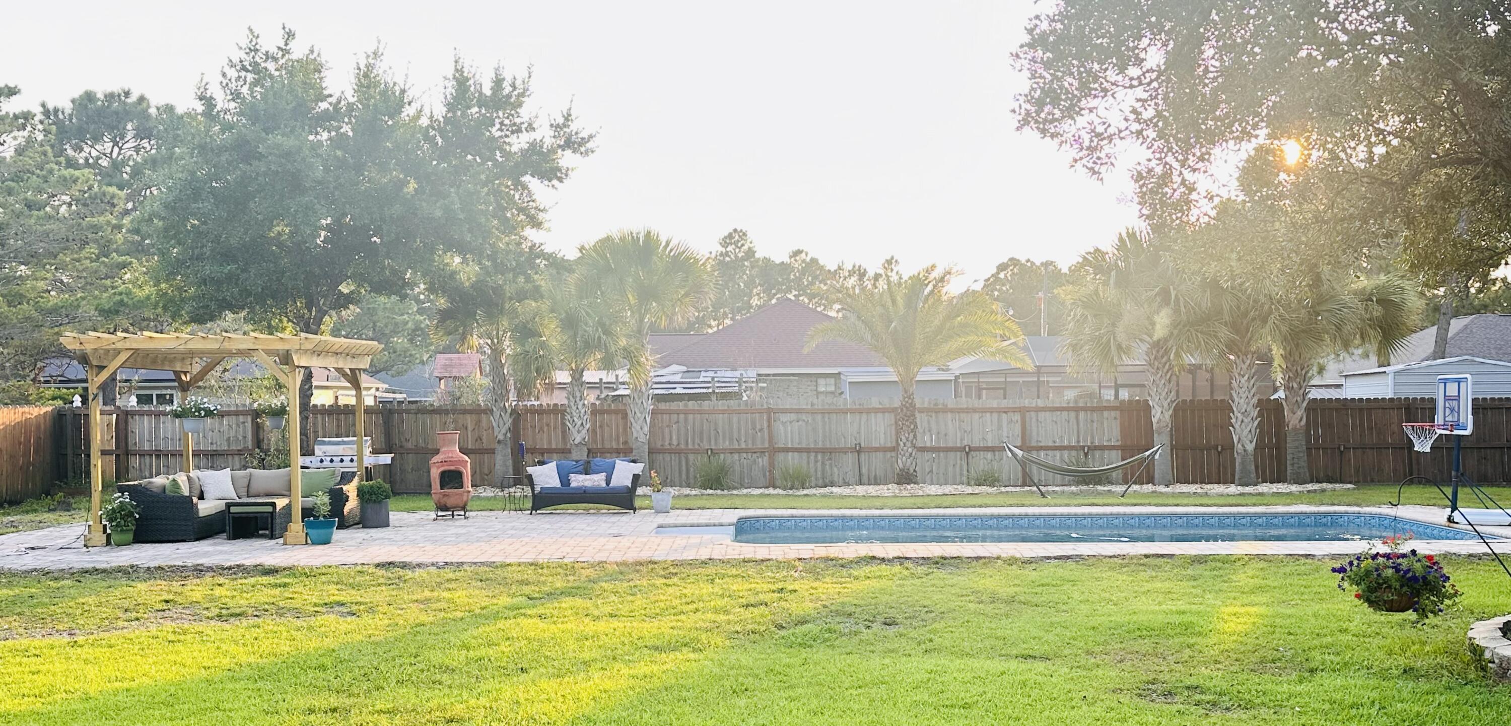 1959 Commodore Drive Navarre, FL 32566 - Photo 48 of 56 a view of a swimming pool with outdoor seating and yard