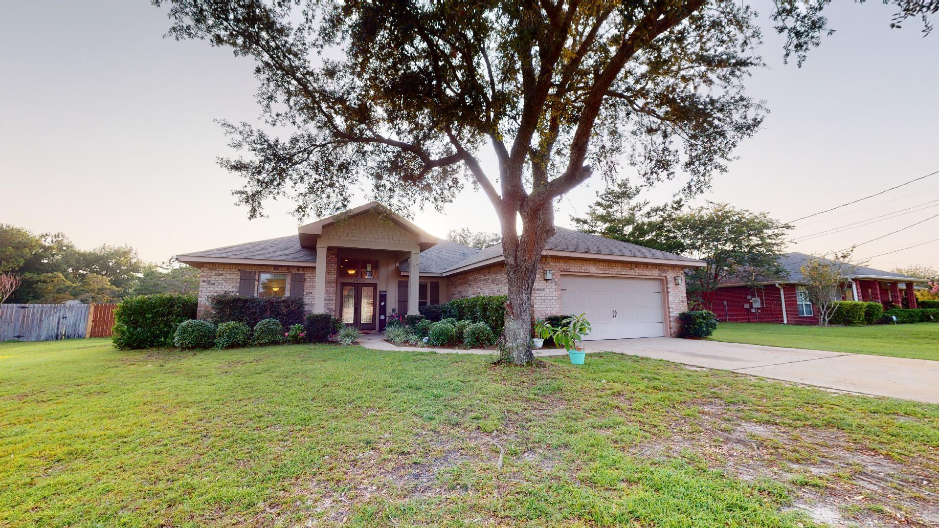 1959 Commodore Drive Navarre, FL 32566 - Photo 5 of 56 a front view of a house with a yard and garage