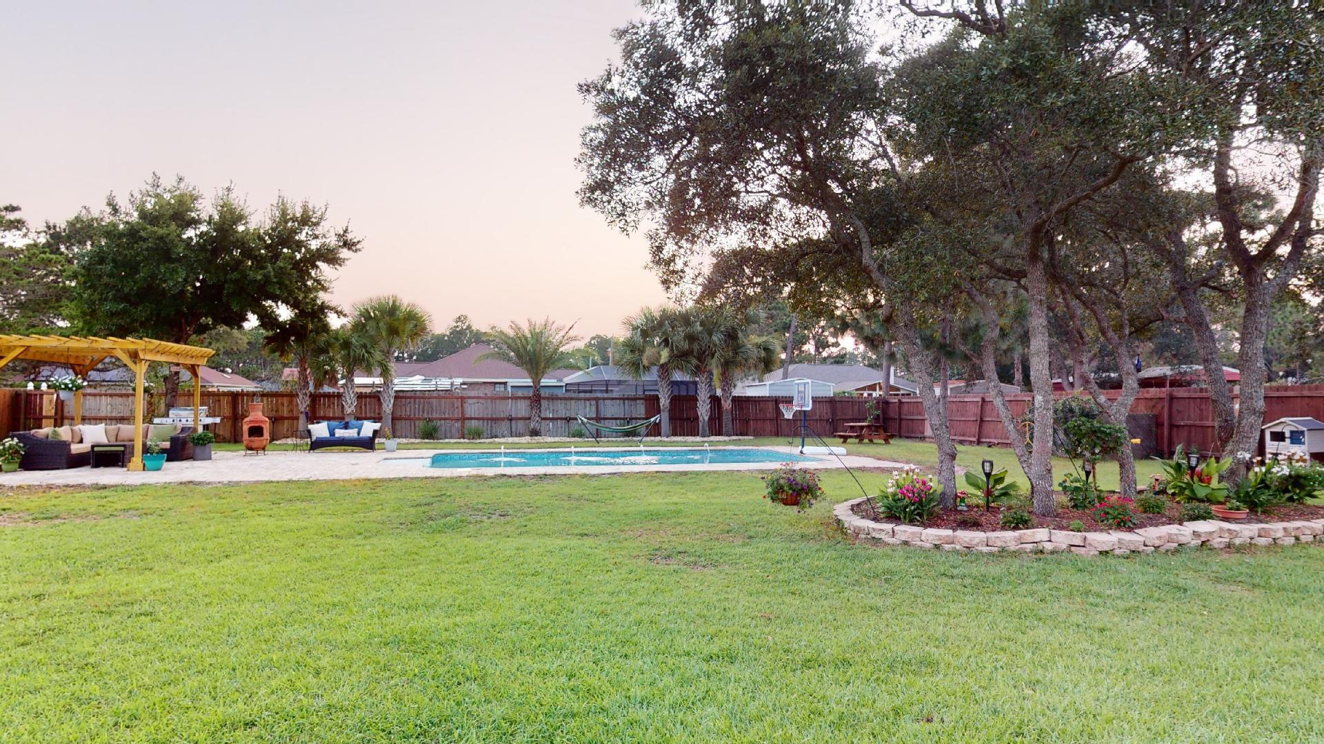 1959 Commodore Drive Navarre, FL 32566 - Photo 52 of 56 a front view of a building with garden and trees