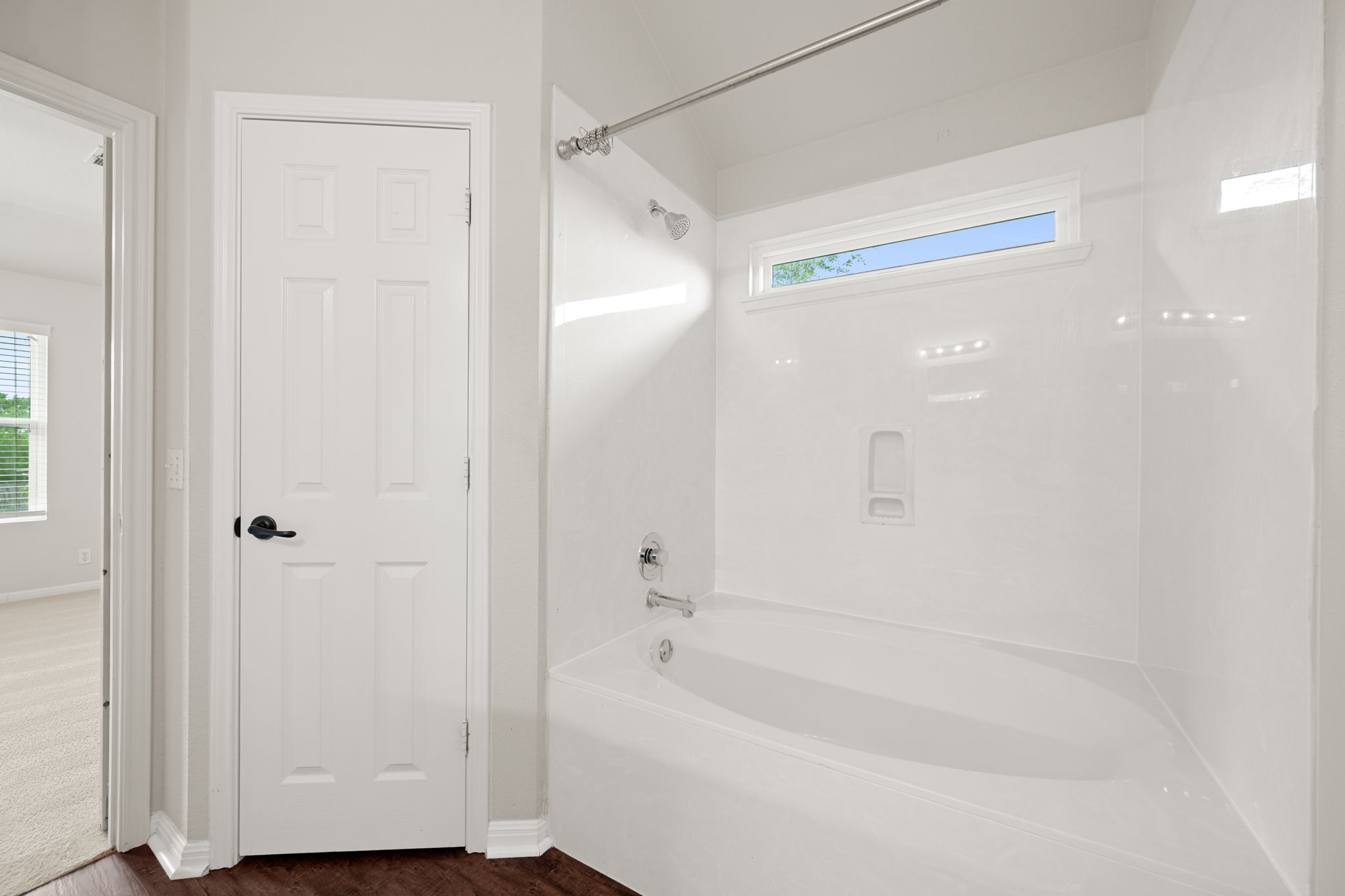 8902 Magna Carta Loop, Unit 122 Austin, TX 78754 - Photo 19 of 39 A well-lit primary bathroom features a pristine tub and shower combination with a privacy window.