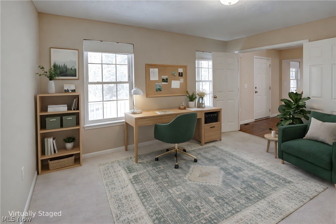 Office space with light carpet and plenty of natural light