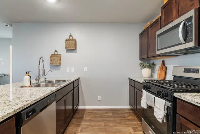 a kitchen with stainless steel appliances granite countertop a sink stove and cabinets