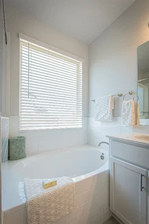 a bathroom with a bathtub and a window