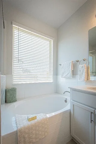 a bathroom with a bathtub and a window