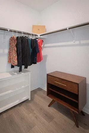 a view of walk in closet with clothes and shoes