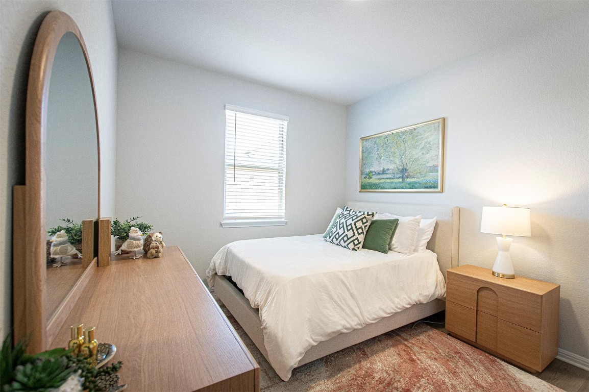 249 Treadwell Lane Kyle, TX 78640 - Photo 25 of 32 a bedroom with a bed and a chandelier