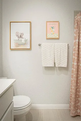 a white toilet sitting next to a white wall