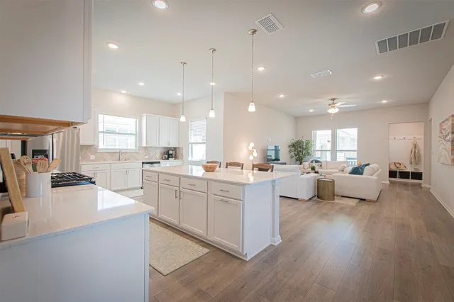 a large white kitchen with lots of counter space dining table and chairs