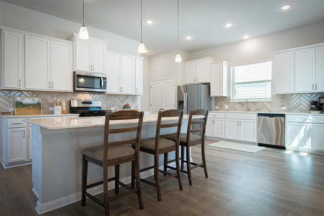 a kitchen with a table chairs refrigerator and microwave