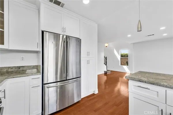 a kitchen with stainless steel appliances granite countertop a refrigerator and a stove top oven