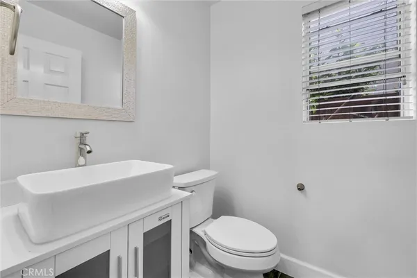 a bathroom with a sink a toilet and mirror
