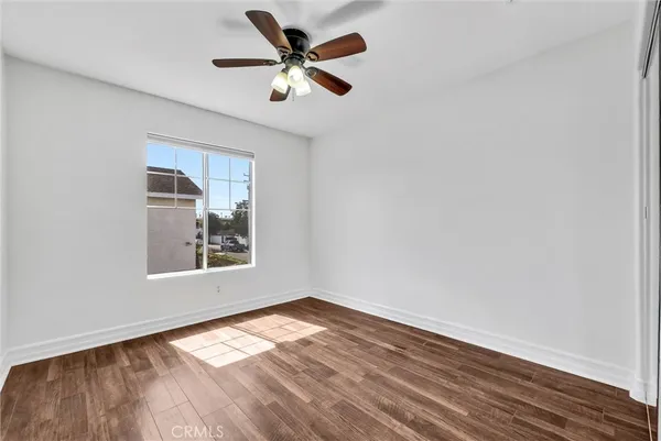 an empty room with a window and ceiling fan