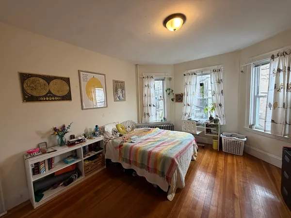 a bedroom with a bed and wooden floor