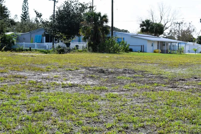 a view of a house with yard and sitting area