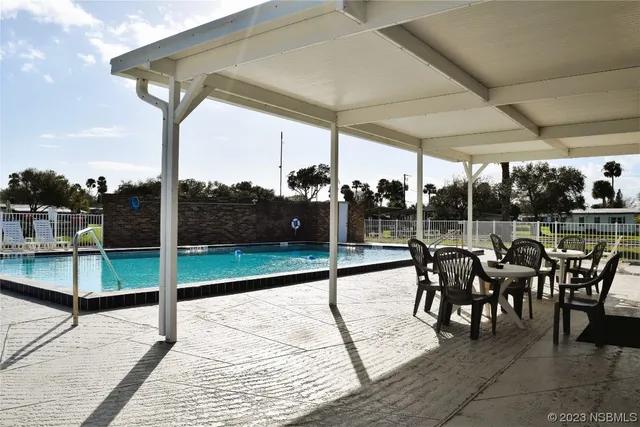 a view of a patio with a table chairs and garden