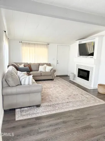 a living room with furniture a flat screen tv and a fireplace