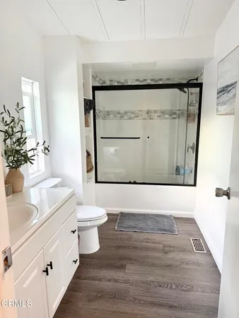 a bathroom with a sink a toilet a mirror and vanity