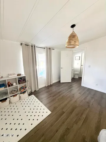 a spacious bedroom with a bed and wooden floor