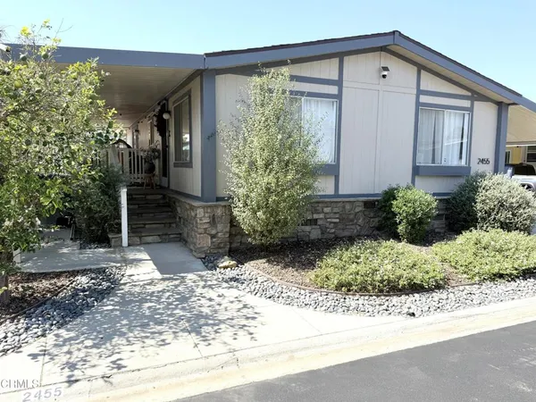 a kitchen with stainless steel appliances a sink a stove a refrigerator cabinets and wooden floor