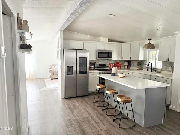 a kitchen with a dining table chairs and sink