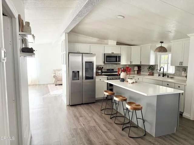 a kitchen with a dining table chairs and sink