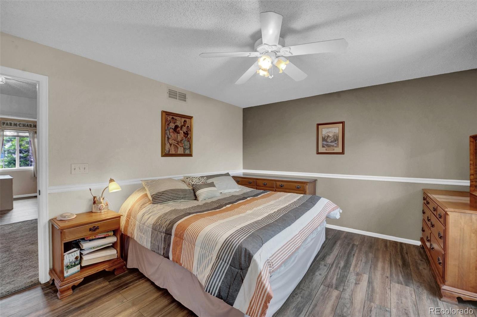 9867 South Castle Ridge Circle Highlands Ranch, CO 80129 - Photo 23 of 40 a bedroom with a bed and wooden floor