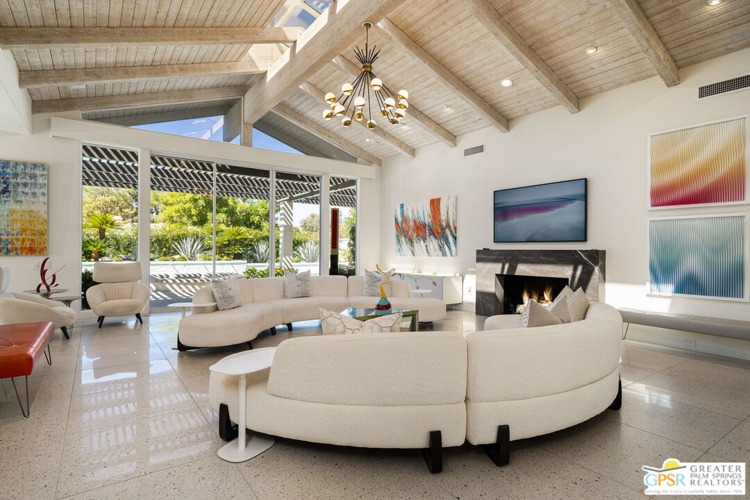 a living room with furniture a chandelier and a flat screen tv