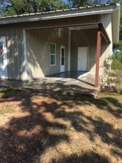 a view of a house with backyard and sitting area