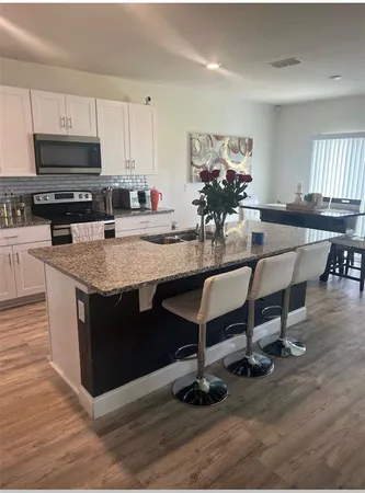 a view of kitchen with sink dining table and chairs