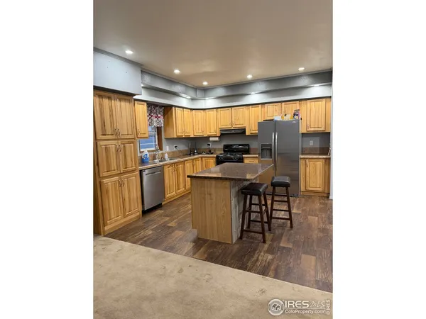 a kitchen with stainless steel appliances granite countertop a refrigerator and a stove top oven