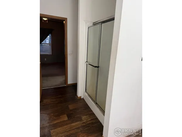 a view of a hallway with wooden floor