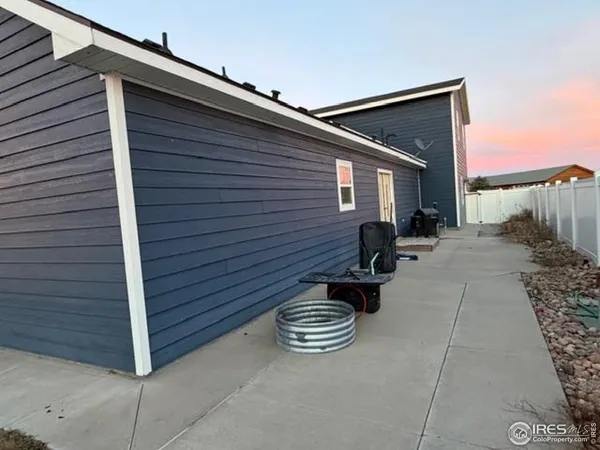 a view of backyard with a grill and a wooden fence