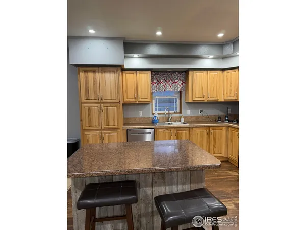 a kitchen with stainless steel appliances a dining table chairs and a sink