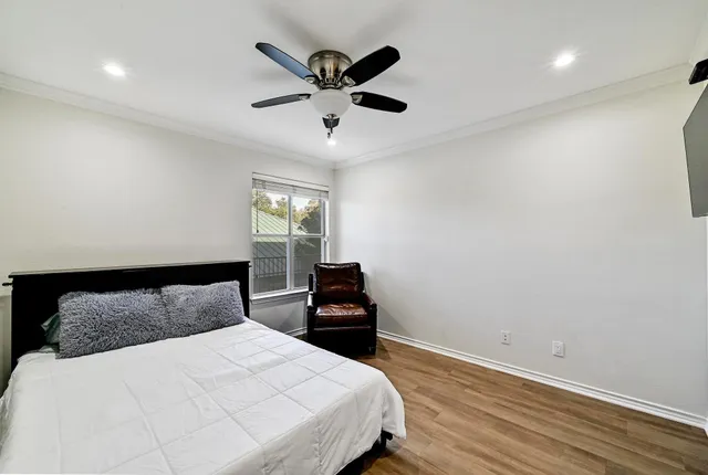 a bedroom with a bed and a ceiling fan