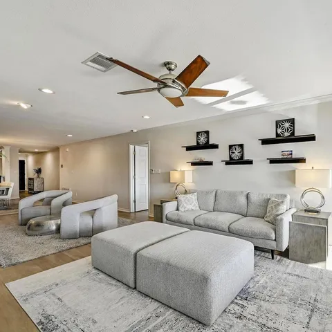 a living room with furniture and a ceiling fan